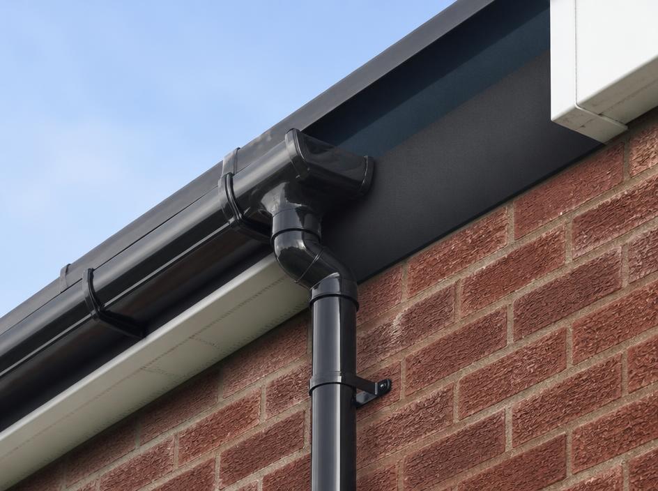 New black guttering and downpipe on a brick house