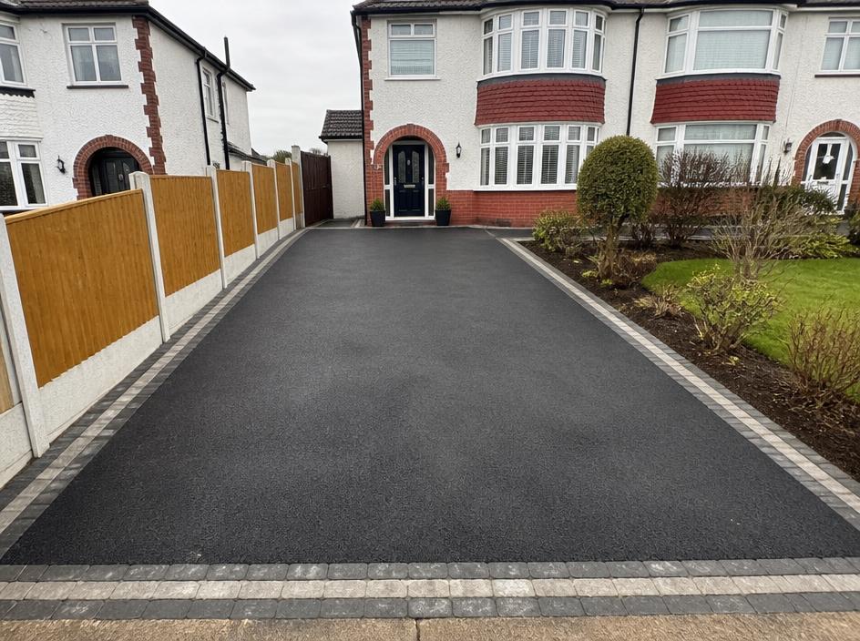 Freshly laid black tarmac driveway with block-paved edging