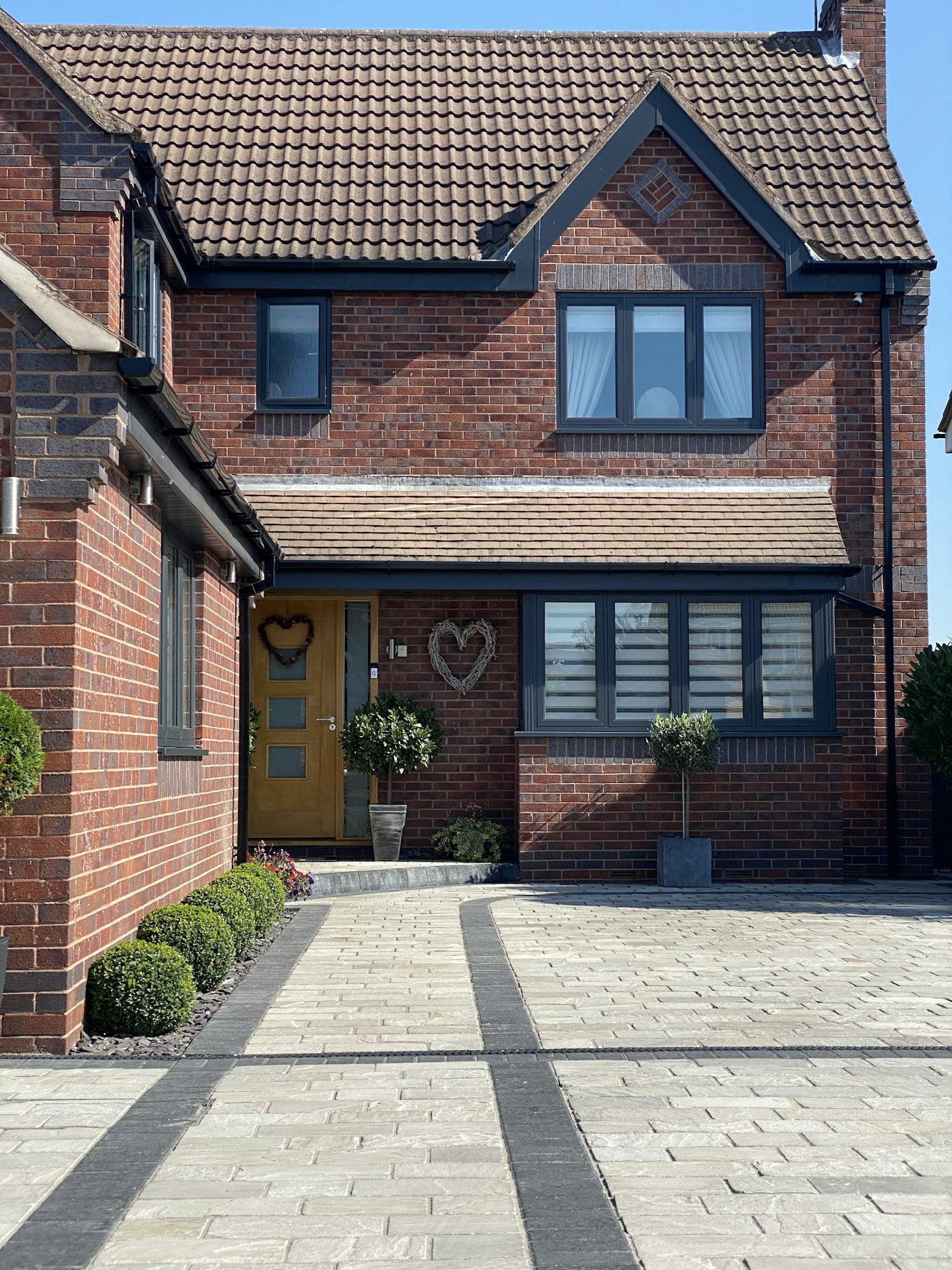 Newly laid charcoal block paving driveway in herringbone pattern at a UK detached home